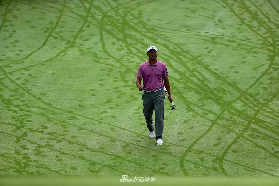 球员王煦在球道上冷静观察，他目光坚定地审视着前方的果岭，仿佛正在脑海中预演最佳的攻击路线