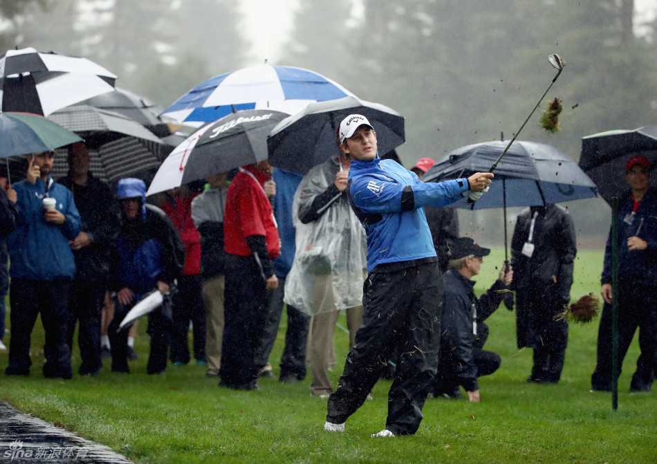 比尔·哈斯与球童在果岭边蹲身认真研读推杆线路，团队协作无间。