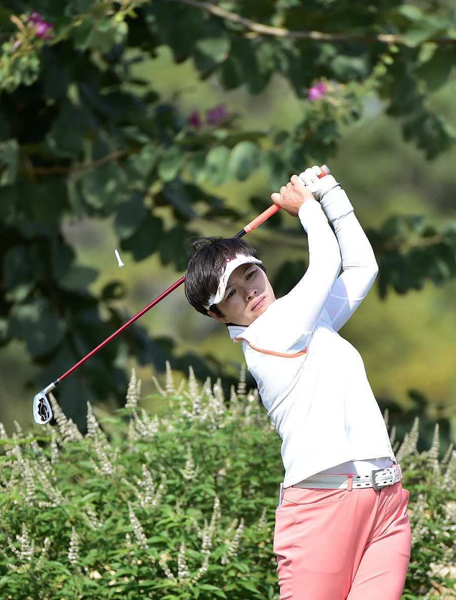 姜艳娇在雨中从容挥杆，雨丝勾勒出杆头划破空气的轨迹，展现了她无惧恶劣环境的专注与潇洒。