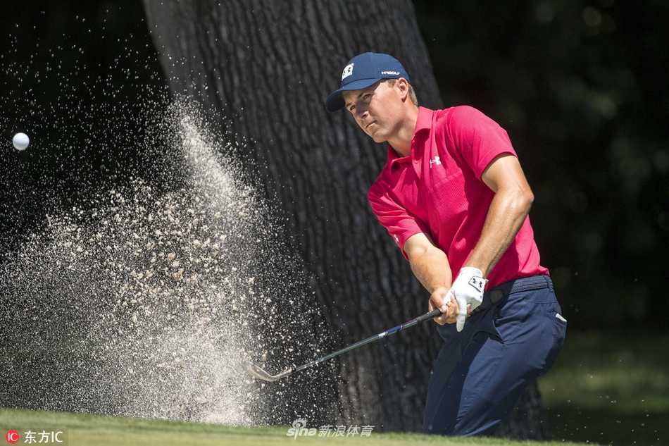 乔丹·斯皮思在球道沙坑中半蹲身姿，谨慎观察球位，思考脱困之策