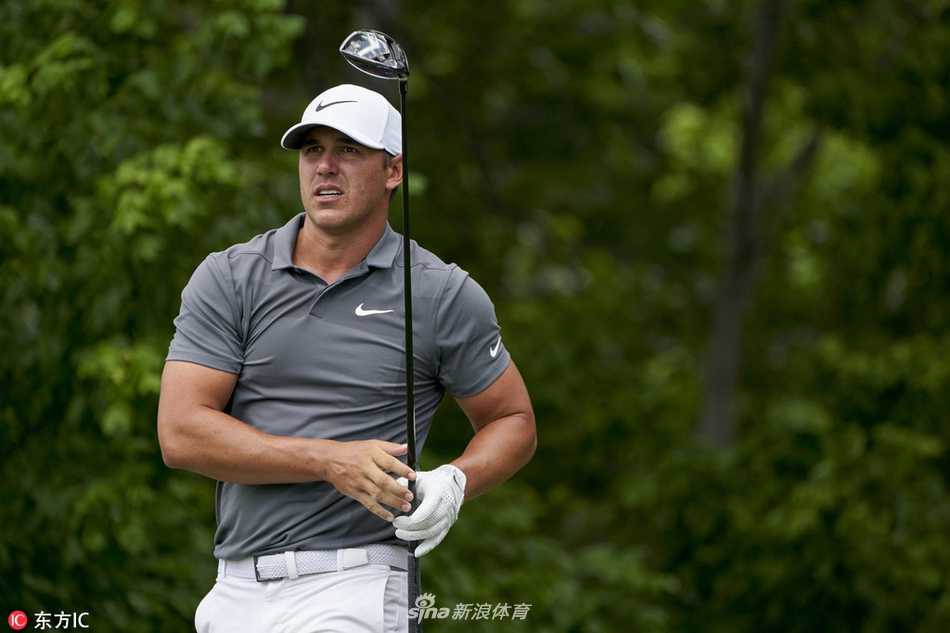 罗斯在果岭边屈膝查看码数本，神情专注，为关键一击做最后准备