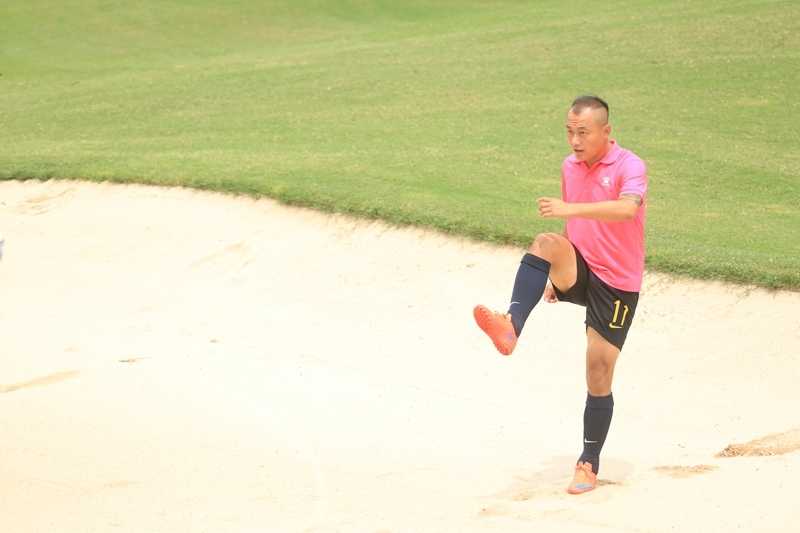 女足国脚谭茹殷在足球高尔夫赛场边，面带微笑专注地观察球场地形，为即将开始的跨界挑战做准备。