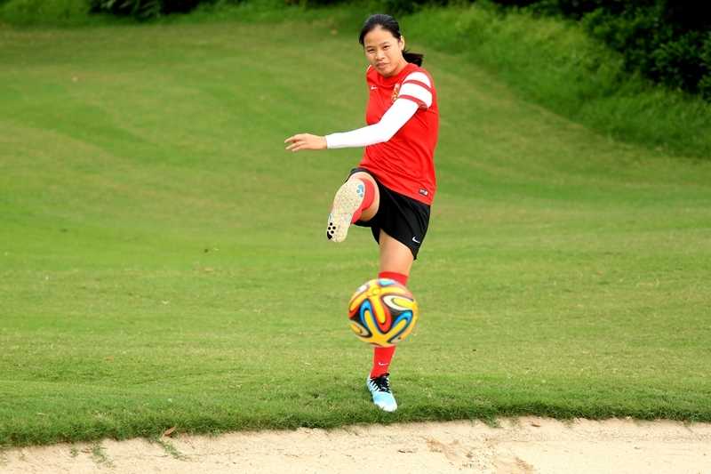 谭茹殷在绿意盎然的高尔夫球场上起脚远射，足球在空中划出一道有力的弧线，展现出女足国脚的精湛脚法。