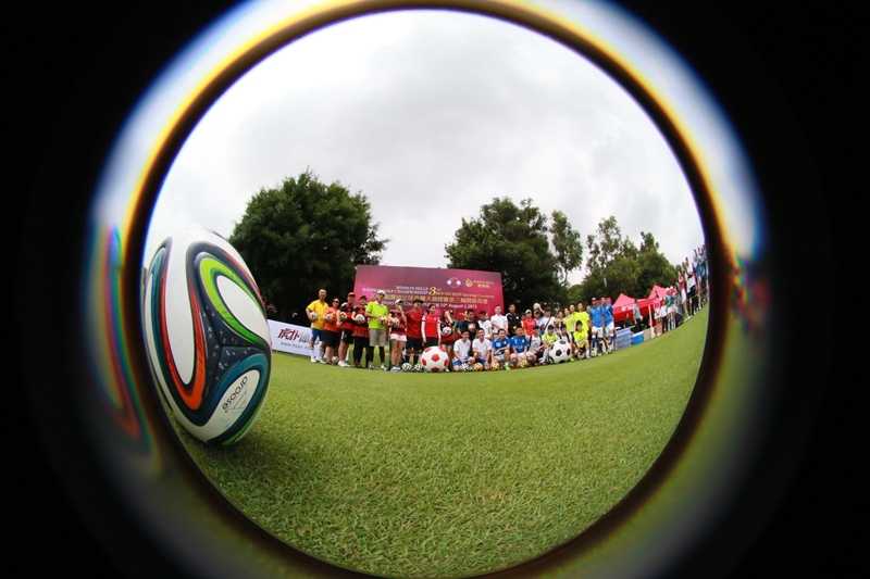 另一位外籍选手正在果岭上仔细推敲，准备完成关键一击，展现了足球高尔夫运动的策略性。