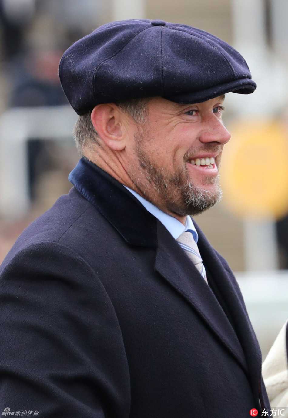 维斯特伍德举起手机，变身为认真的场边摄影师，他的妻子也微笑地注视着同一方向，两人共同分享着捕捉精彩瞬间的乐趣。