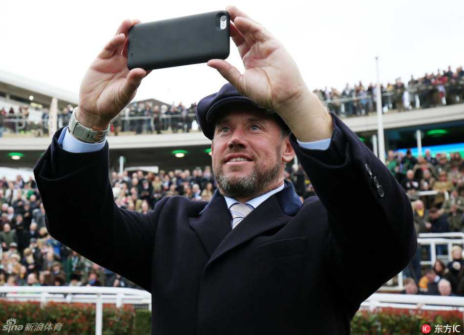 一阵风起，维斯特伍德迅速抬手扶住头上的贝雷帽帽檐，这个动作为他专注观赛的形象增添了一丝诙谐与生活气息。