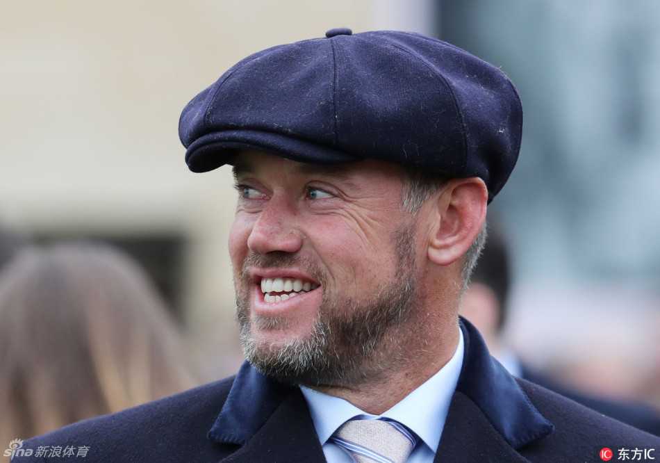 维斯特伍德与妻子在观赛间隙默契地对视微笑，轻松愉快的氛围在他们之间流淌，展现了赛场下的温馨时刻。