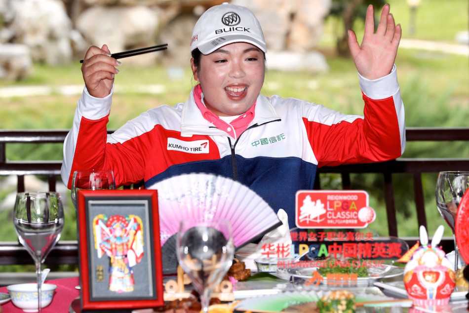 杰西卡·柯达在练习场边随着节奏快乐起舞，金色的头发飞扬，为严肃的赛场注入了一丝活泼的旋律。