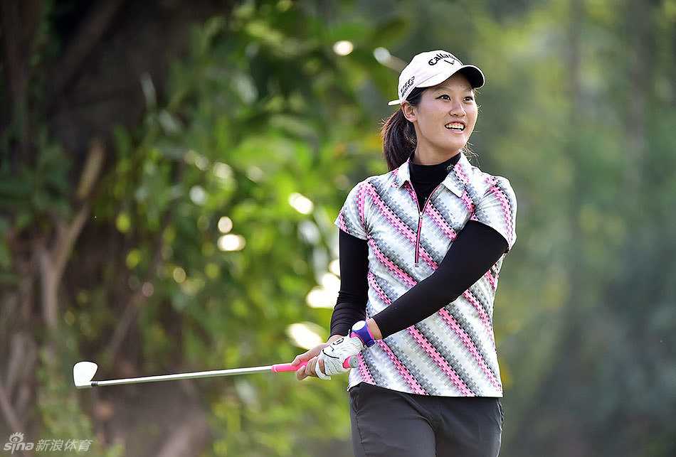 石昱婷推杆成功后开心挥手庆祝，笑容灿烂与同伴分享喜悦时刻