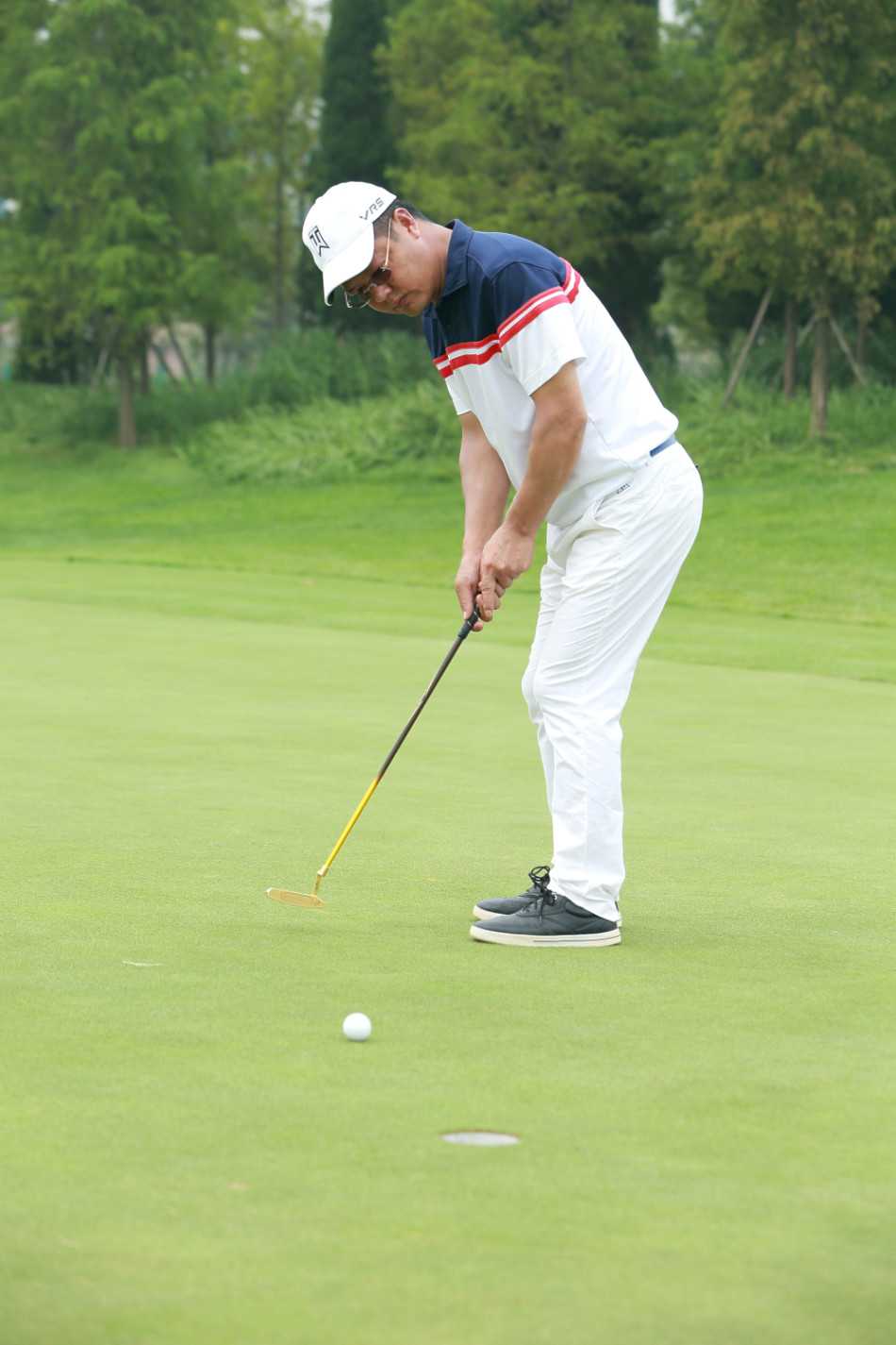 队员们齐聚果岭旁愉快合影，背景是开阔的球场与蓝天，每个人脸上都绽放着灿烂的笑容