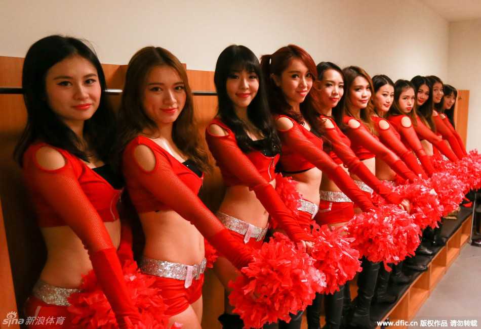 啦啦队队员们身着闪亮队服，在球场中央跃起，马尾辫在空中划出活力的弧线