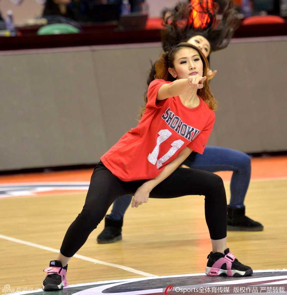 动感舞姿火力全开，姑娘们手持花球整齐划一，修长身姿在球场灯光下划出优美弧线。