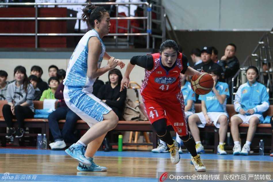 新疆队球员外线出手，篮球在空中飞翔，北京队球员上前封盖瞬间