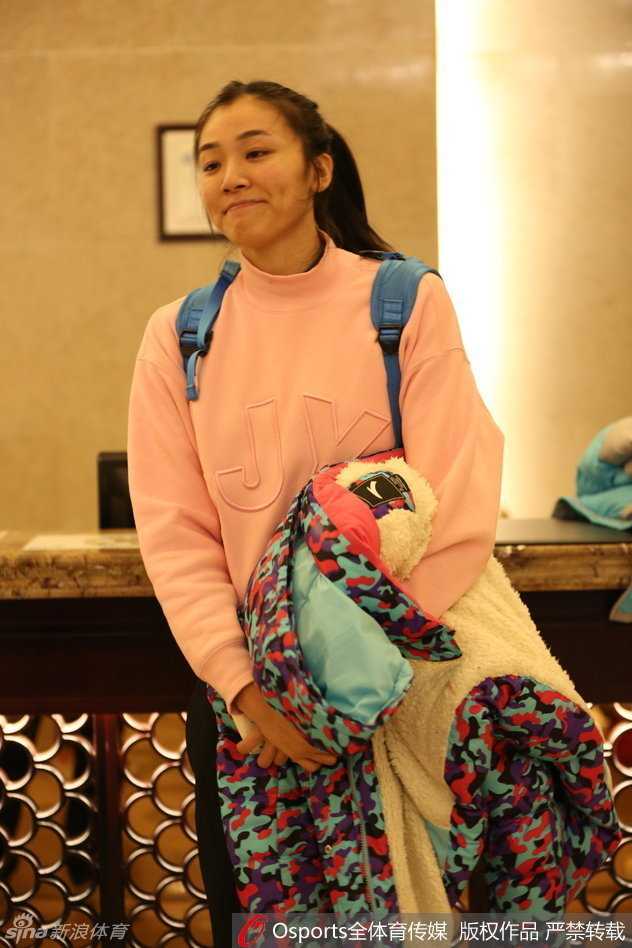 队长露雯在赛场上展露自信微笑，双手叉腰神情轻松，尽显女篮核心的从容气质