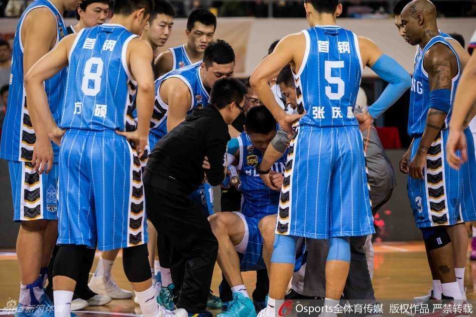 马布里神情关切地蹲在孙悦身旁，用手轻触其肩膀低声询问，孙悦摇头示意疼痛难忍，整个首钢队替补席笼罩在紧张的气氛中。