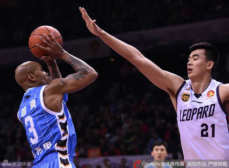 张庆鹏弯腰弓背死死贴防对手，手臂不停干扰传球路线，脸上写满了不服输的坚韧与专注。