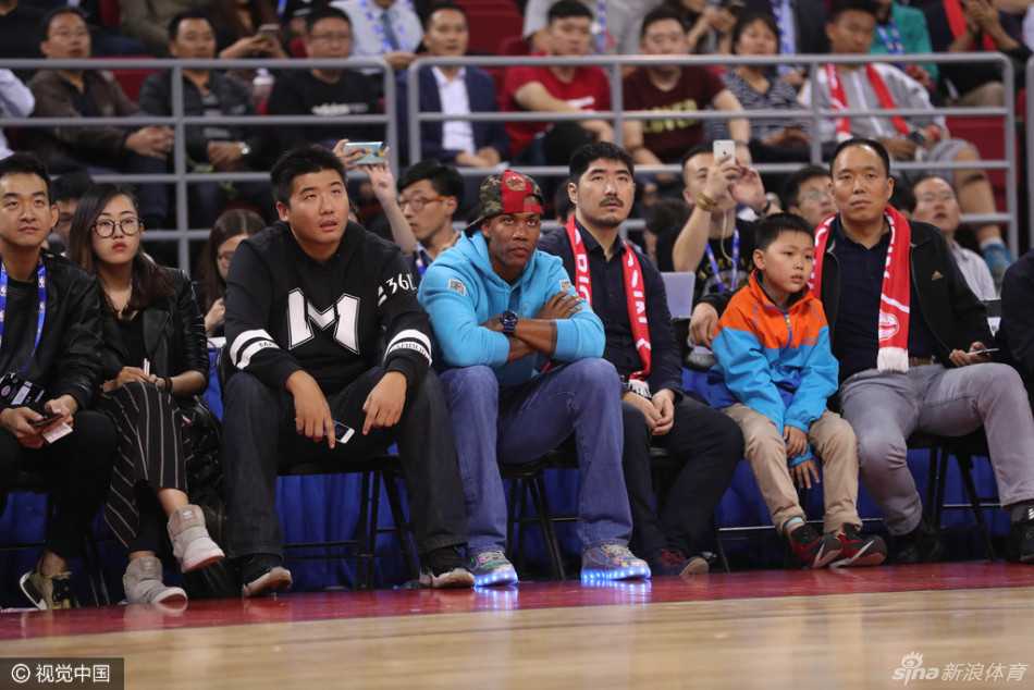 灯光璀璨的五棵松篮球馆内，马布里安静地坐在场边座椅上，眼神专注地凝视着赛场中央，仿佛在品味着昔日的NBA记忆。