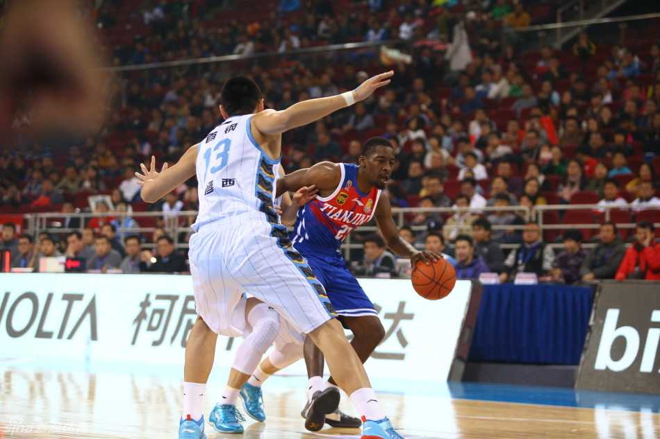 翟晓川在篮下迎着两名防守球员高高跃起，上演惊天补篮，身体在空中完全舒展，展现了惊人的弹跳和顽强的拼劲。