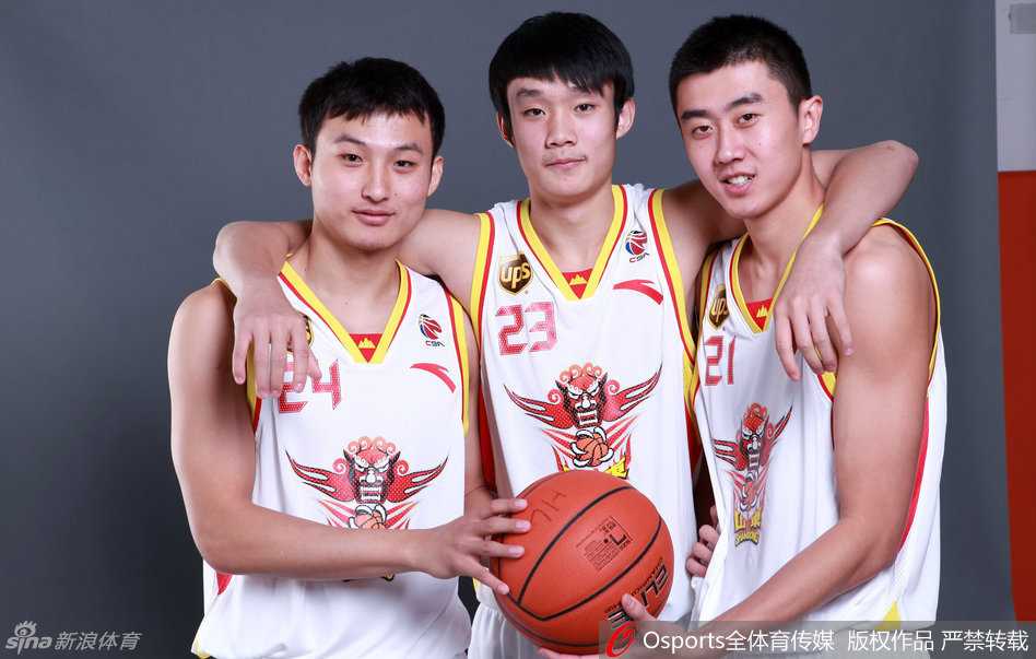 王汝恒与丁彦雨航在场边神情专注地交流，两人眼神交汇间，是多年并肩作战培养出的无声默契。