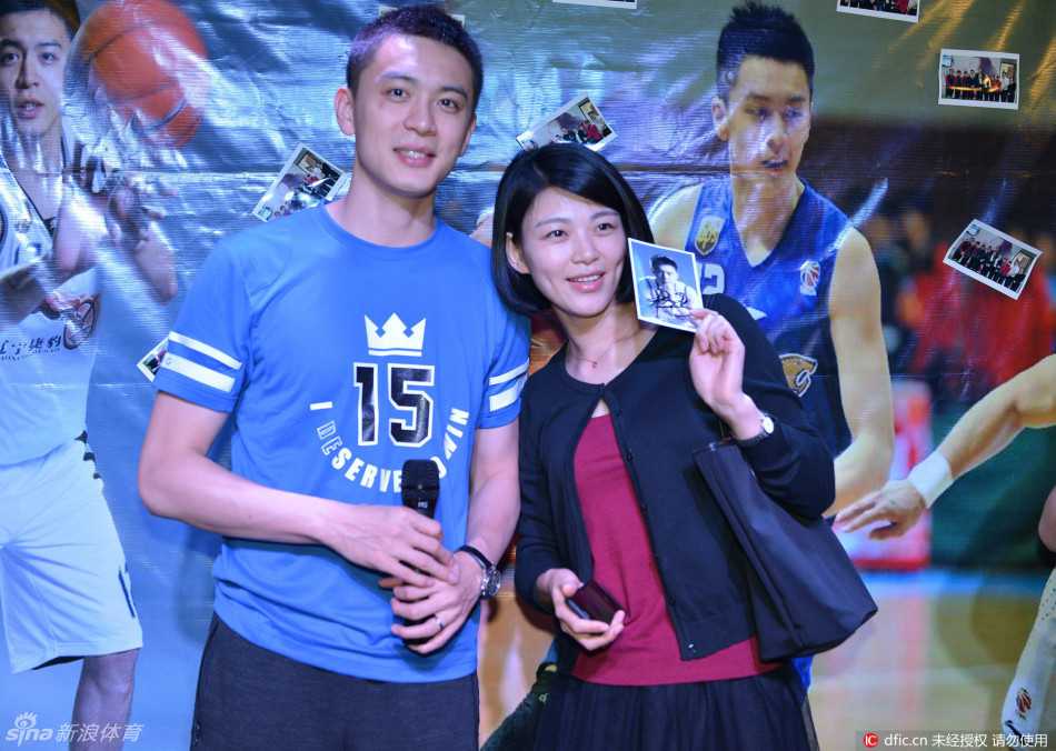 身着简约蓝色T恤的杨鸣，正微微俯身与身边笑容灿烂的女粉丝一同看向镜头，画面定格在他那标志性的俊朗侧颜与亲切互动上。