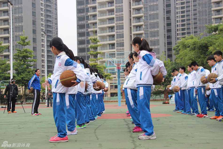 前深圳主帅李群的篮球人生下半场:投身校园公益,从华师附小抓起 小队员在场上进行动作示范,李群站在身侧认真观察准备随时纠正细节