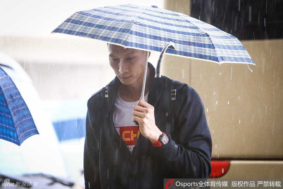 绝对的领袖易建联独自撑着一把黑色大伞，神情冷峻地从酒店步出，仿佛将外界的纷扰与大雨一同隔绝，那份沉稳正是当时那支年轻国家队的定海神针。