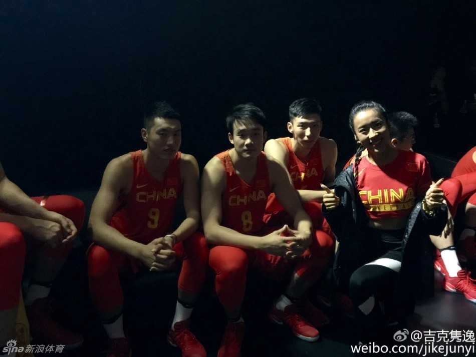 台下合影时，吉克隽逸笑容灿烂地坐在男篮队员中间，她身上那抹红色不仅是中国队的象征，也点燃了现场热烈的助威气氛。