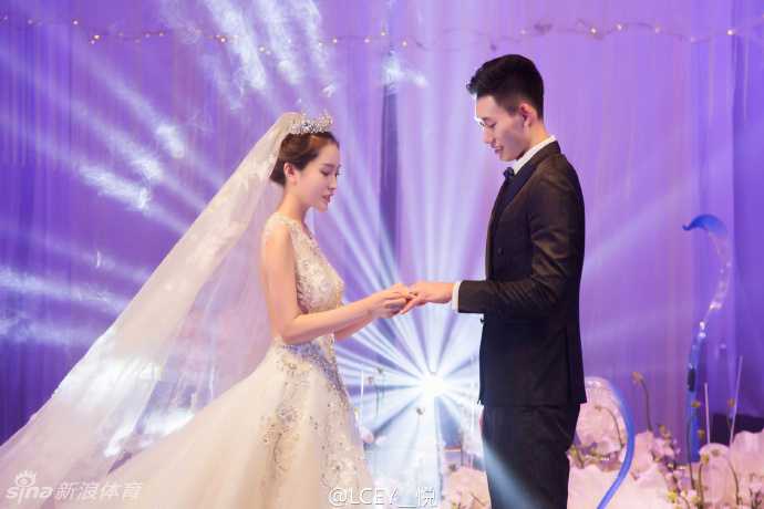 吉林男篮锋卫王镤大婚 身高两米硬汉抱得美人归 身披洁白婚纱的新娘手捧鲜花,与身穿深色礼服的新郎王镤在宴会厅内深情对视,眼中满是爱意与甜蜜