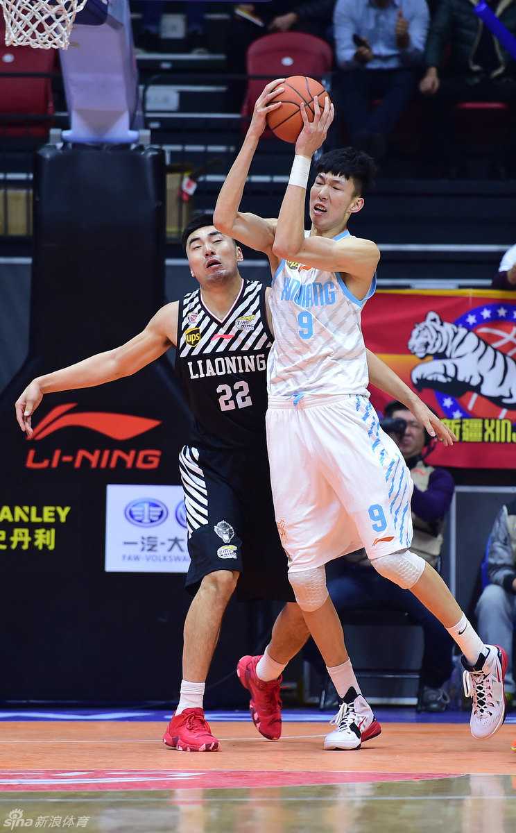 周琦布拉切筑天山,新疆飞虎席卷CBA赛场 周琦面对防守球员准备起跳投篮,他高举篮球,利用身高臂展优势,试图在对手头顶完成一次轻松的投射。