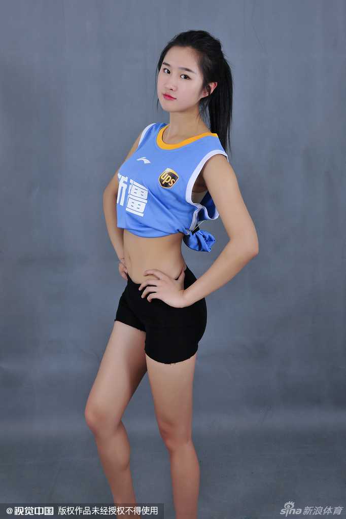 看台上的少女头戴新疆队标志性的发带，手托下巴，神情专注地盯着赛场，纯净的眼神中充满了对主队下一次进攻的期待。