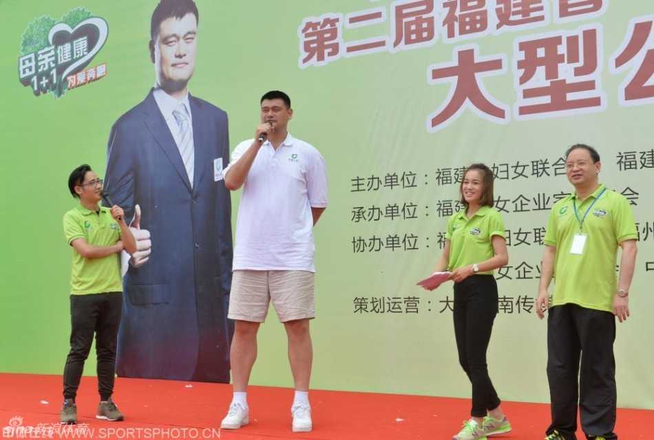 姚明在舞台中央发表讲话，他手握话筒，神情专注而诚恳，身后的背景板上写着“为爱奔跑”的主题字样，台下是密密麻麻、全神贯注聆听的观众。