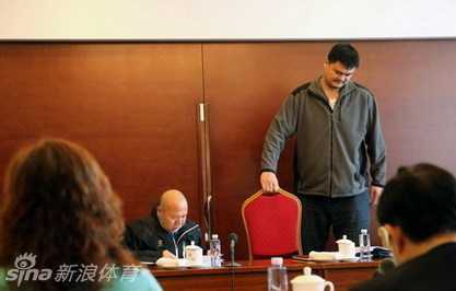 换上一把普通折叠椅后，姚明的膝盖几乎要顶到前面的桌子，但他脸上的神情却变得专注而轻松，双手捧着文件认真阅读起来。