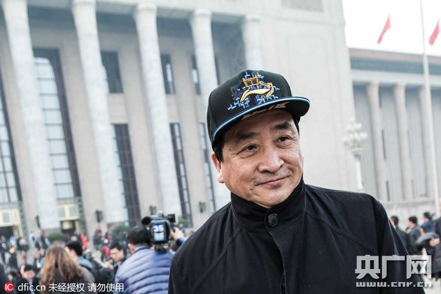 姜昆两会行:头顶冠军荣耀,心怀国学未来 在热烈的分组讨论间隙,姜昆手持会议材料与身旁委员热络交流,身后的会标与眼前专注的神情构成一幅生动的议政图景。