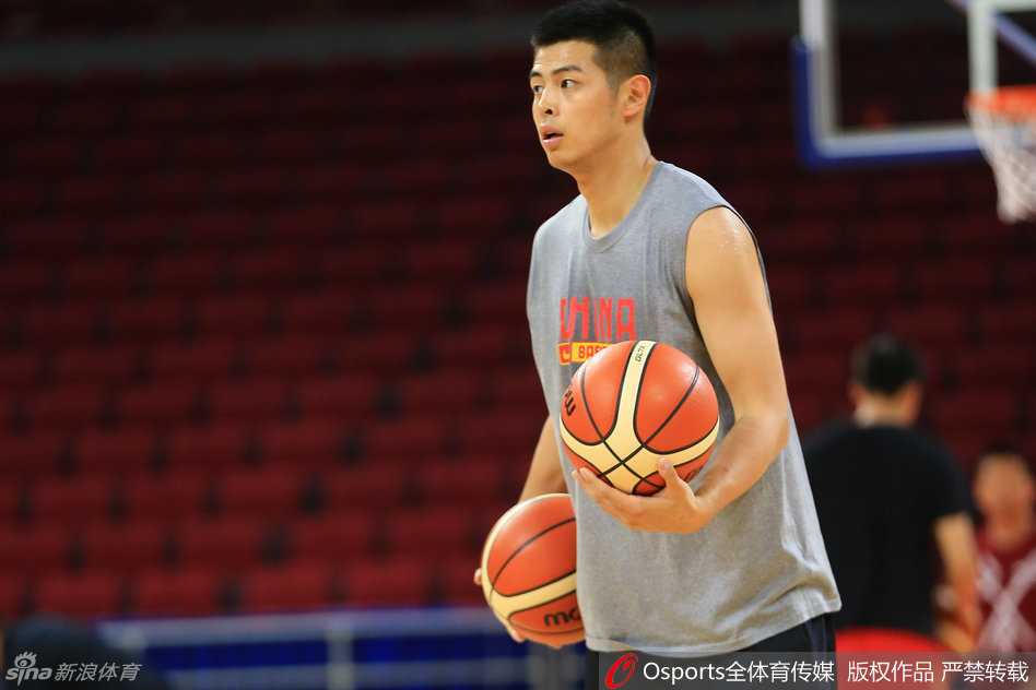 主教练宫鲁鸣手持战术板，正在为队员们详细讲解战术跑位，神情严肃而认真