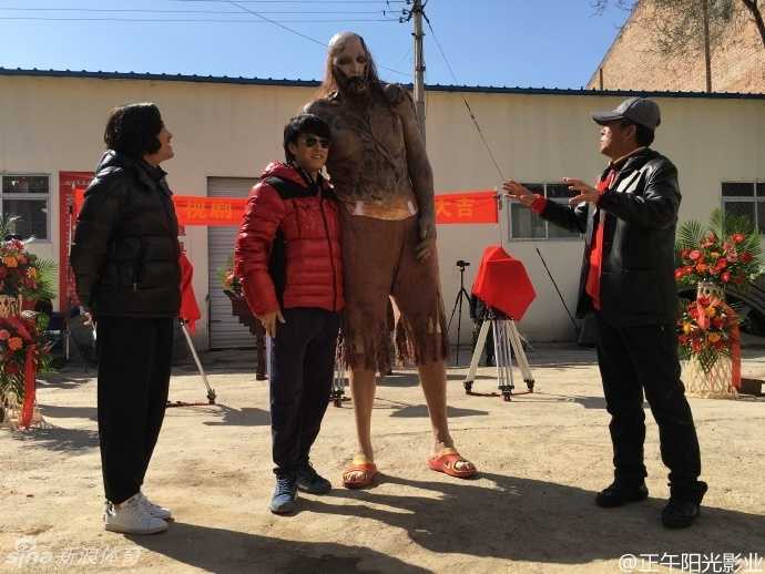 巨人孙明明的惊悚跨界:两米三六的身高,只为演活《鬼吹灯》里的“红犼” 片场休息时,一身戏服的孙明明与工作人员进行交流。为了角色剃光头的他,在妆容的加持下显得格外另类,但他神态轻松,仿佛早已习惯了这副骇人的外表,也让人看到了他为了角色付出的敬业精神。