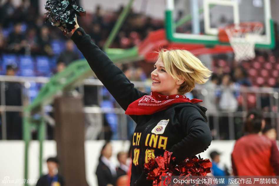 异国热舞助阵中委女篮对抗赛:激情飞扬为中国队喝彩 一位啦啦队员手持蓝色花球,自信地面对镜头,洁白的牙齿和弯弯的笑眼展现出她迷人的魅力,仿佛阳光洒满赛场。