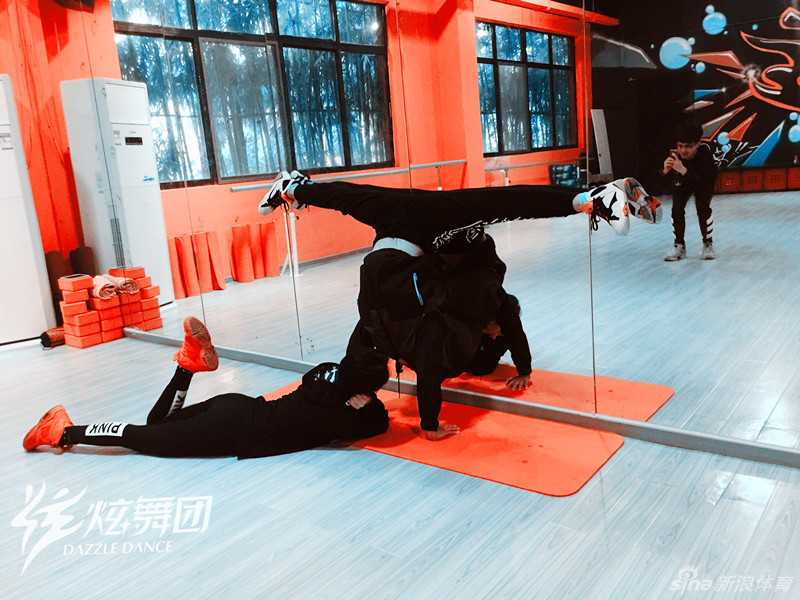 惊艳一字马壁咚背后 是舞者用汗水浇筑的柔韧与力量 一名舞者正在进行基本功训练,她以墙为辅助,努力拉伸韧带,身体线条展现出柔韧与力量交织的独特美感。