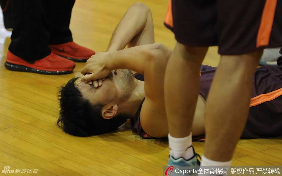 韩德君坐在场边长凳上，魁梧的身躯此刻却显得无比落寞，他双手抱头久久不愿抬起，似乎无法接受队友重伤的事实，背影写满了担忧与心痛。