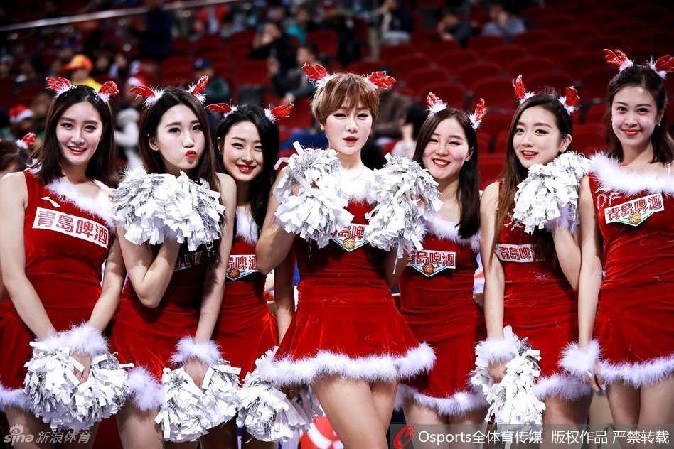 拉拉队圣诞热力秀,点燃萧瑟冬日球场 一位拉拉队员戴着闪闪发光的圣诞头饰,对着镜头露出甜美的微笑,身后的队友们形成虚化的背景,充满了青春的活力。