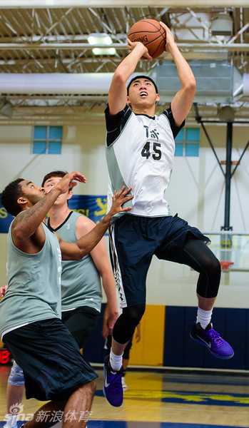 挥汗亚特兰大,深圳烈豹男篮特训影像纪实 深圳球员在对抗中高高跃起准备投篮,防守球员封到脸上,空中对抗瞬间充满张力。