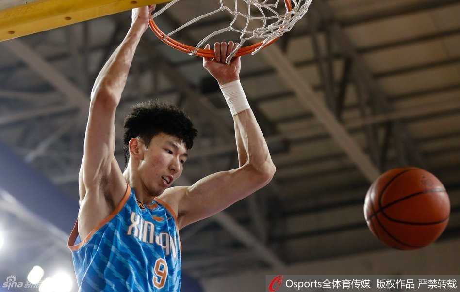 新疆男篮热血季:暴扣与肘击交织的激情岁月 周琦犹如天神下凡,隔着防守球员单臂完成雷霆万钧的暴扣,整个篮筐都在颤抖。