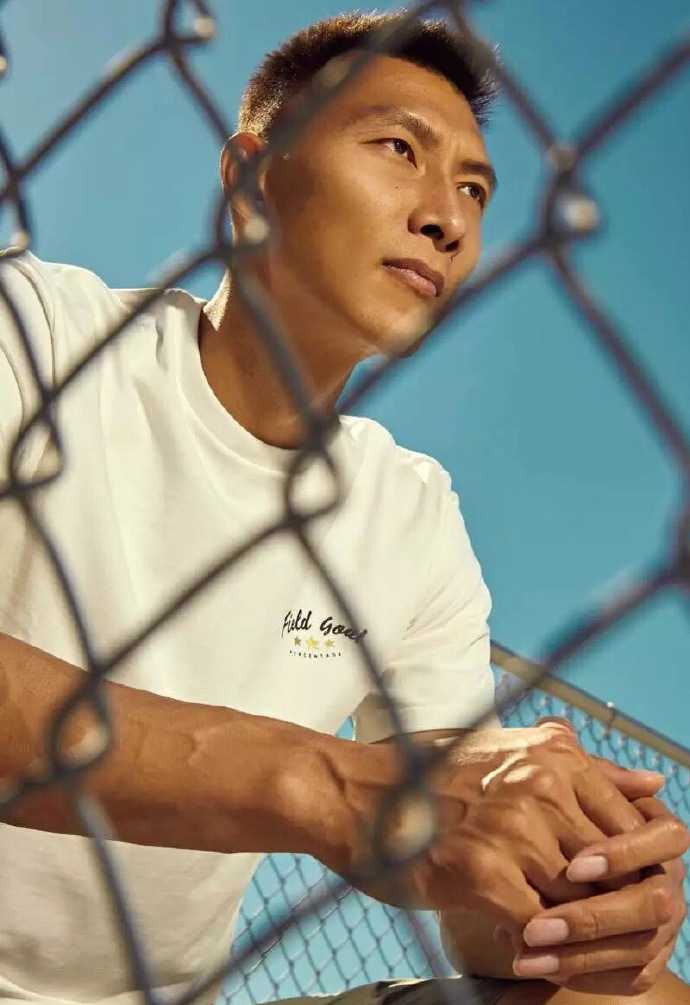 易建联光影之间尽显领袖风范 一个极具张力的特写镜头,易建联微微低头,眼神向上挑起,仿佛在审视猎物的雄鹰,脸部刚毅的线条在光影交错中显得格外立体。