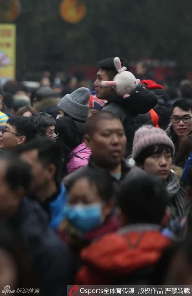 春节邂逅温情:篮球国手常林地坛庙会秀最萌身高差 常林正全神贯注地参与庙会上的趣味游戏,他怀中抱着一个巨大的卡通毛绒玩偶,显然是刚刚获得的战利品,脸上带着轻松愉悦的笑容,尽显硬汉柔情。