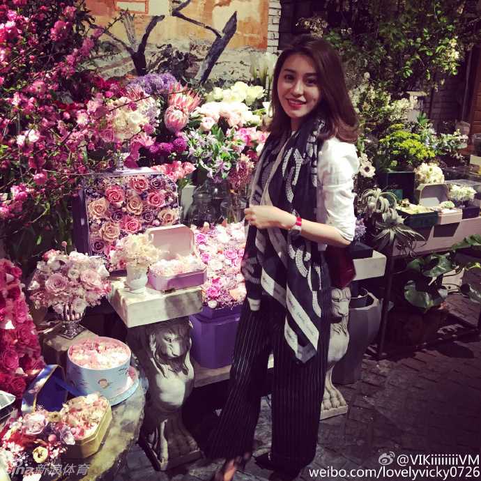 花房姑娘轻嗅芬芳，置身于鲜花丛中的她，笑容比花朵更加娇艳动人