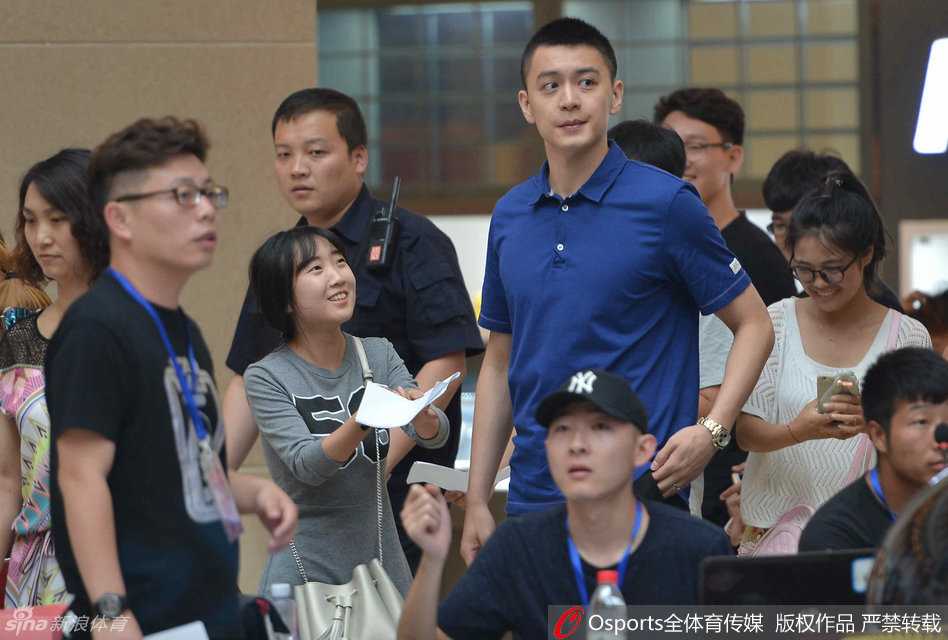 终于拿到签名的女粉丝心满意足，而杨鸣在递回签名笔的瞬间，微微抿嘴露出标志性的腼腆微笑，阳光下的侧脸线条堪称完美。