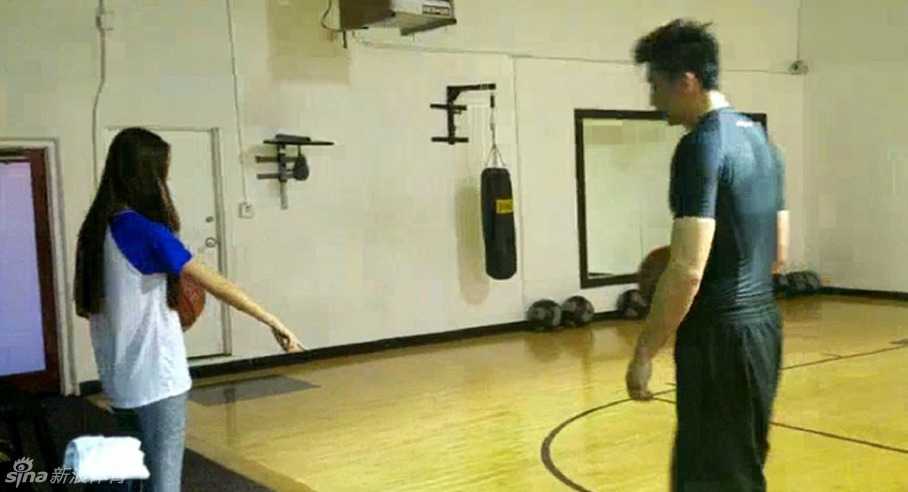 汗水是最好的粘合剂:夫妻力量训练的爱情保鲜密码 妻子做出夸张的防守姿势试图封盖丈夫的投篮,眼神中充满挑衅与爱意