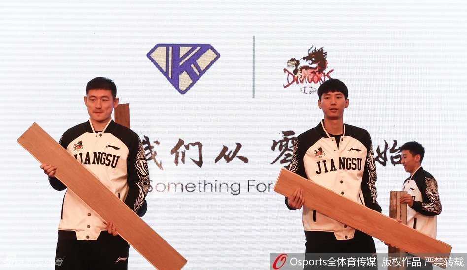 江苏肯帝亚开创新河,人民大会堂誓师出征 江苏肯帝亚队员常林与助理教练徐强在人民大会堂内轻松交流,身后的红色立柱和金色装饰衬托出这一历史性时刻的氛围。