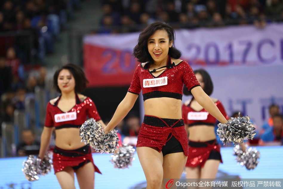 圣诞女郎们身着红白相间的节日盛装，露出灿烂笑容，随着欢快节奏尽情舞动，修长身姿在赛场灯光下格外迷人。