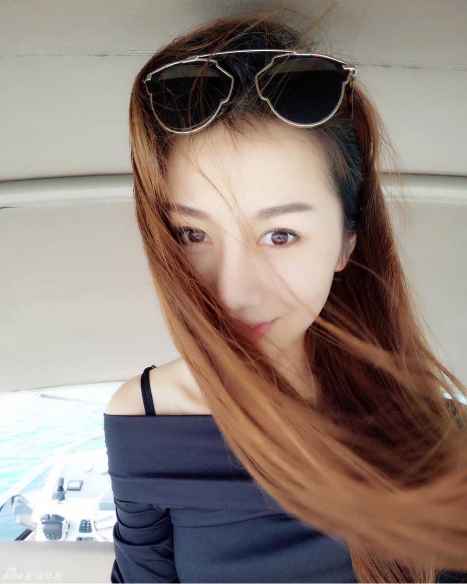 陈露穿着轻盈的夏日长裙，回眸一笑，发丝随风飘动，定格了这个海边最美的瞬间。