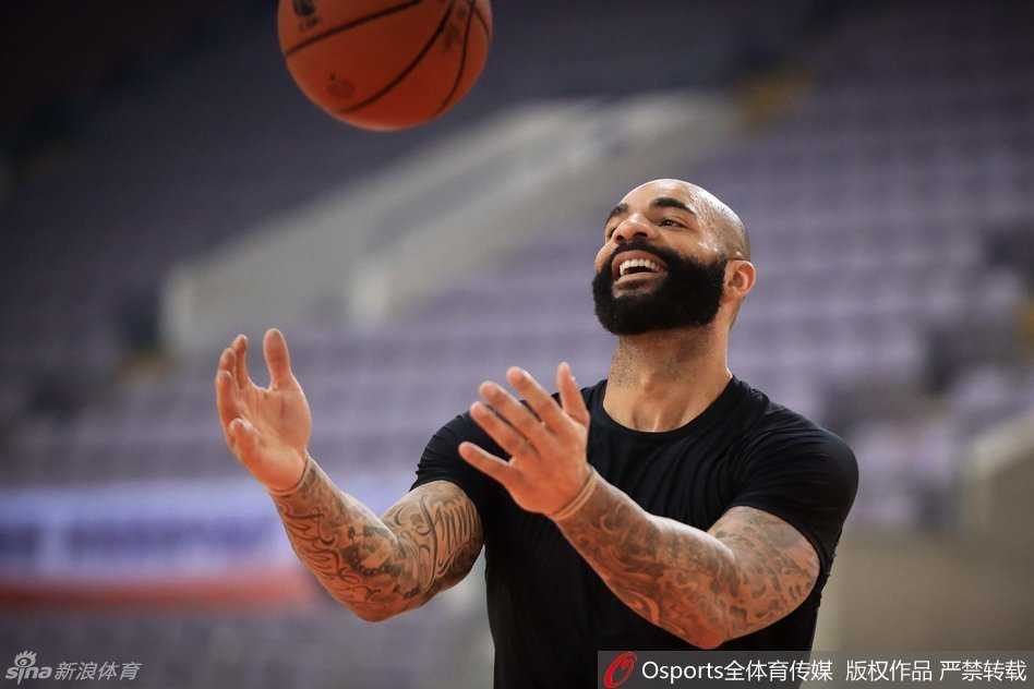 易建联在遭遇包夹时高高跃起，手腕轻抖，巧妙地将球传给篮下空位的队友，这一瞬间充分展现了他的核心策应能力。